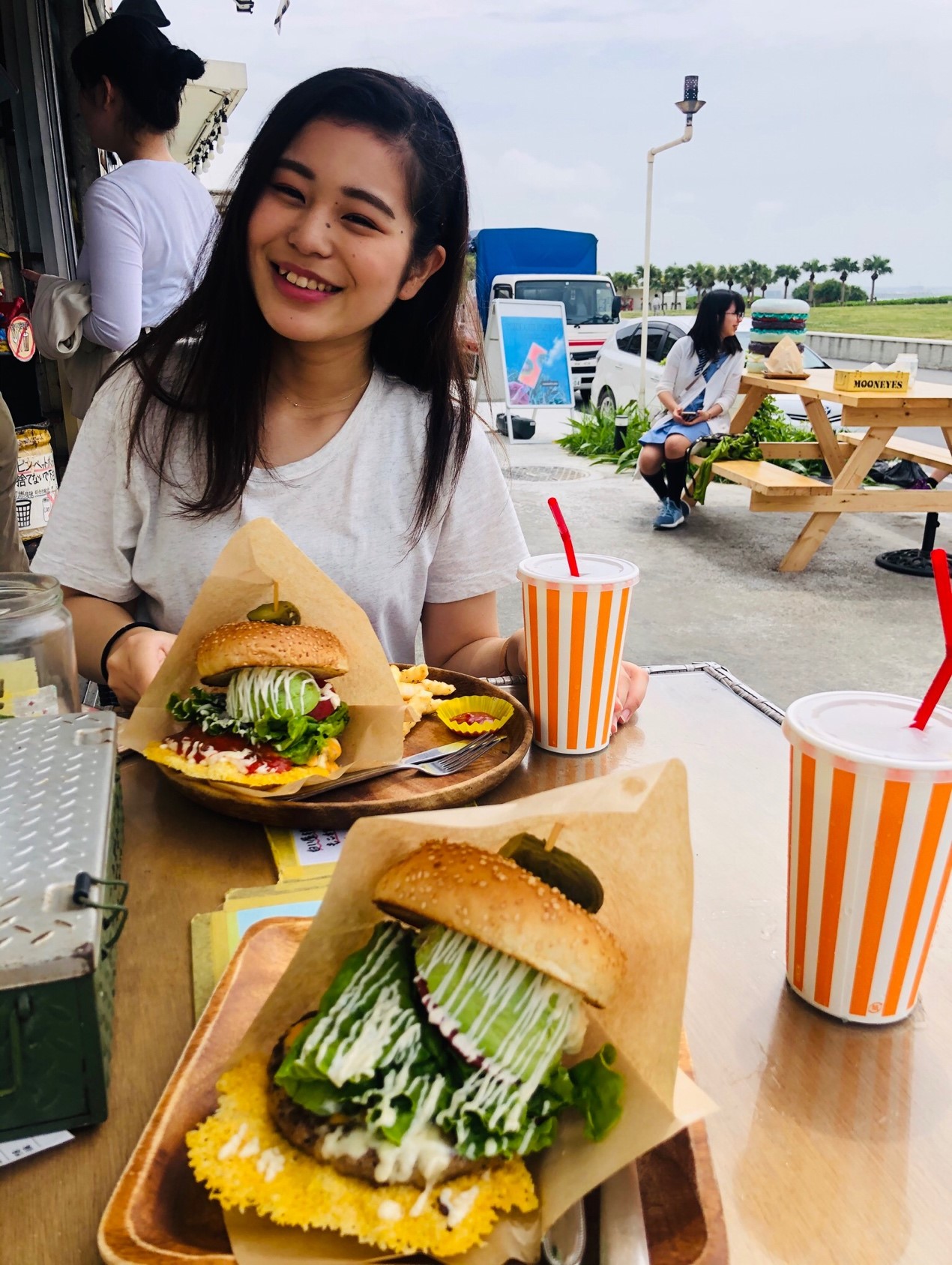 幸せそうな城間さんとスパイシーバーガーとアボカドチーズバーガー